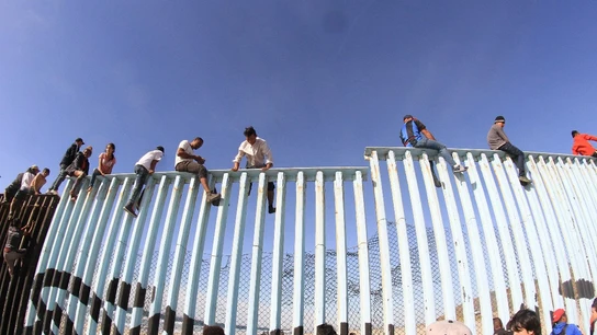 Migrantes saltando la valla fronteriza de EEUU Migrantes saltando la valla fronteriza de EEUU