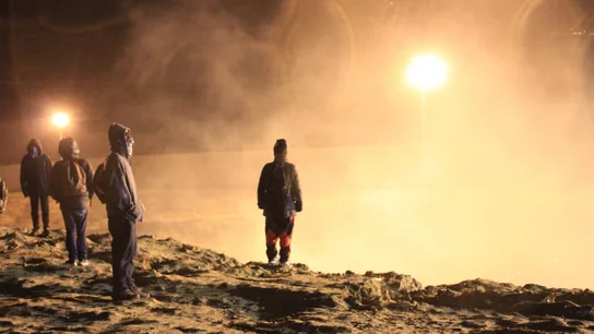 Migrantes esquivan el humo del gas lanzado por los guardias de la Policía fronteriza. Migrantes esquivan el humo del gas lanzado por los guardias de la Policía fronteriza.