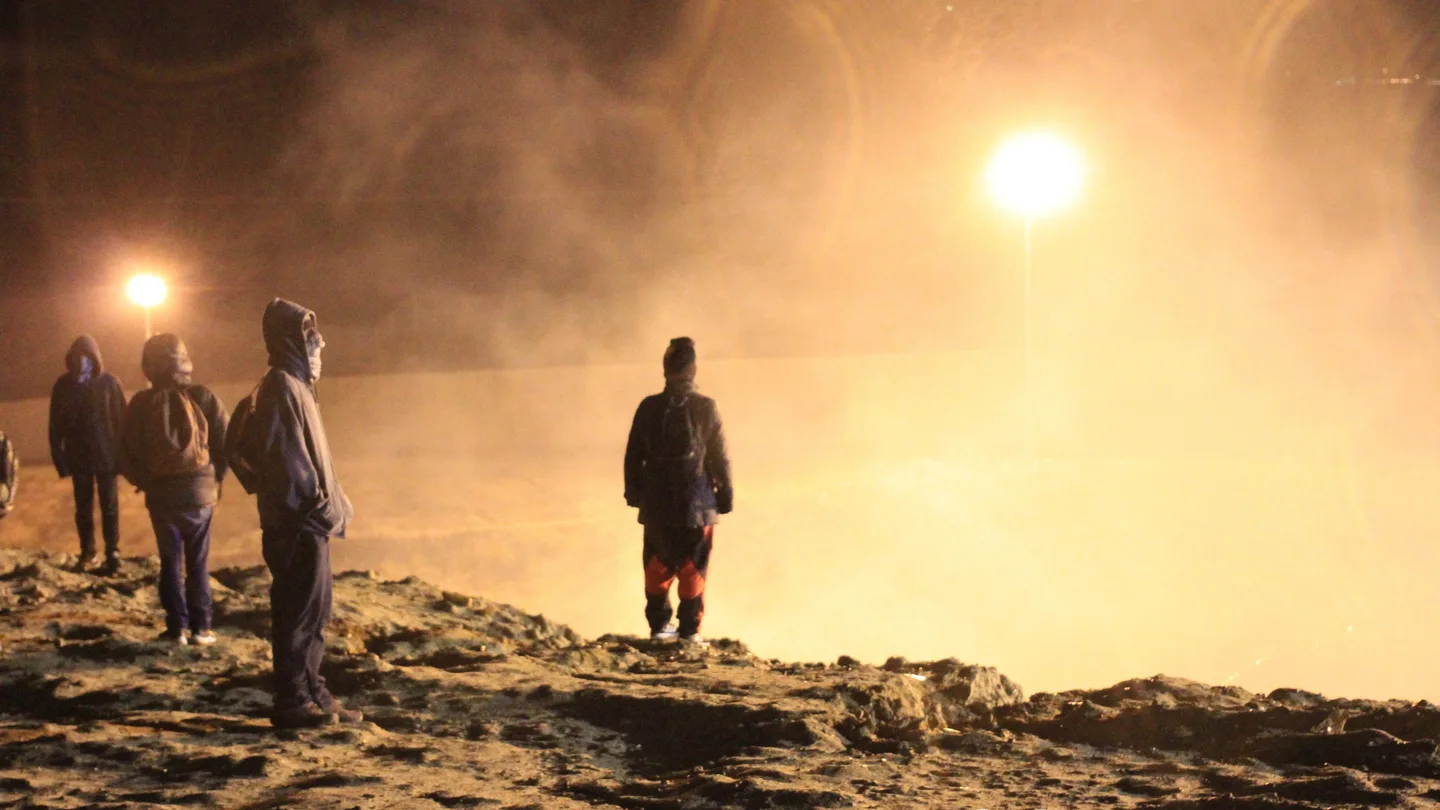 Migrantes esquivan el humo del gas lanzado por los guardias de la Policía fronteriza. Migrantes esquivan el humo del gas lanzado por los guardias de la Policía fronteriza.