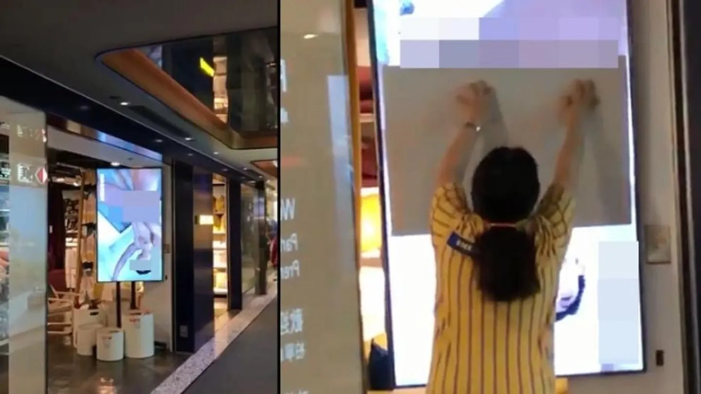 Una dependienta trata de tapar la pantalla de un escaparate de Ikea. Una dependienta trata de tapar la pantalla de un escaparate de Ikea.