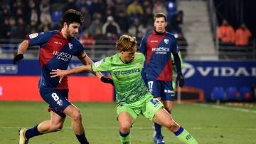 Canales intenta proteger el balón ante la defensa del Huesca