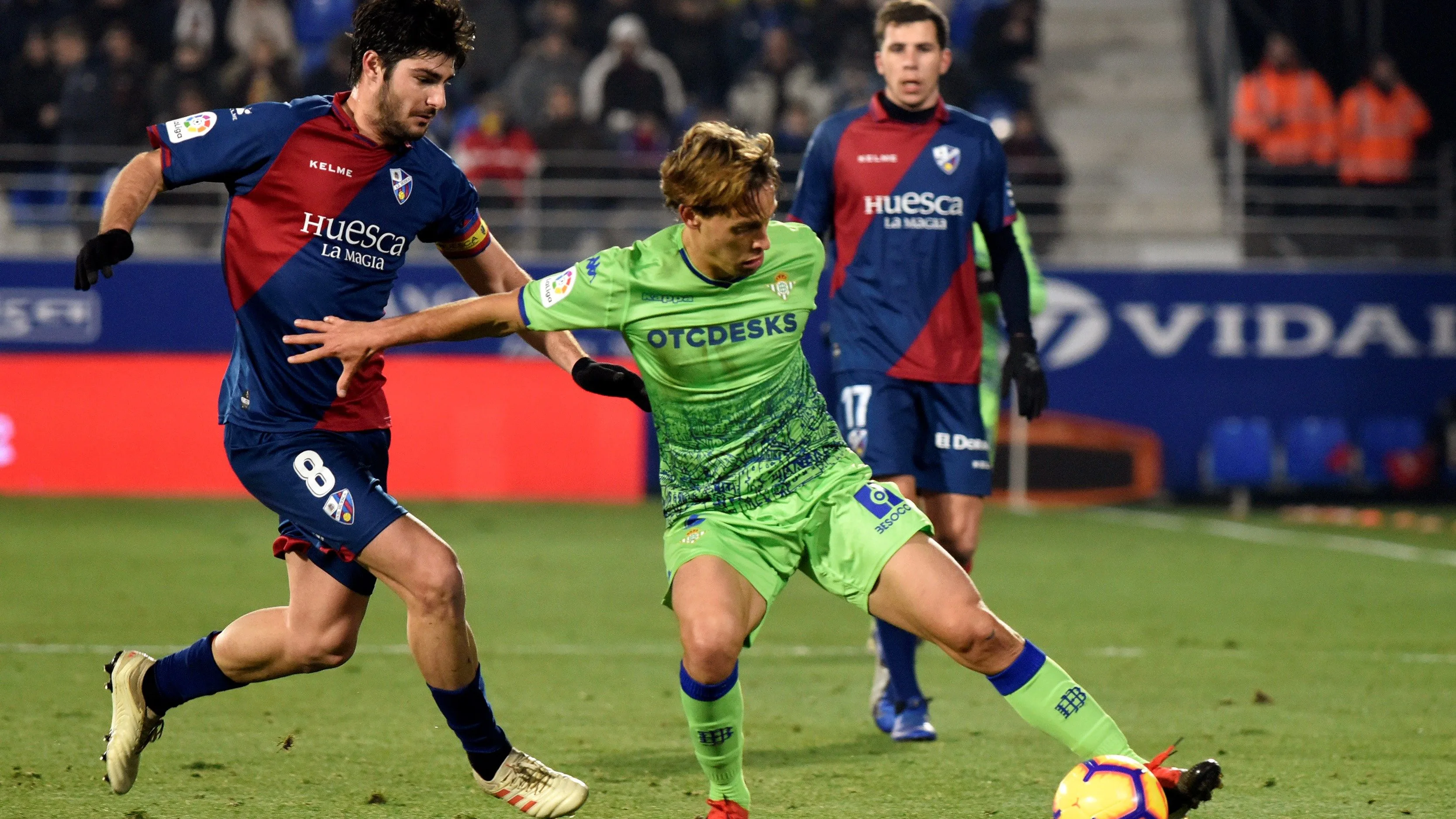 Canales intenta proteger el balón ante la defensa del Huesca