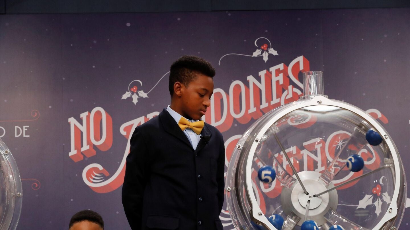 Uno de los ni&ntilde;os de San Ildefonso junto al bombo ya preparado para el sorteo de la loter&iacute;a de El Ni&ntilde;o