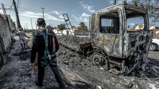 Un hombre camina frente a un vehículo quemado tras un ataque hoy, en Fortaleza (Brasil) Un hombre camina frente a un vehículo quemado tras un ataque hoy, en Fortaleza (Brasil)