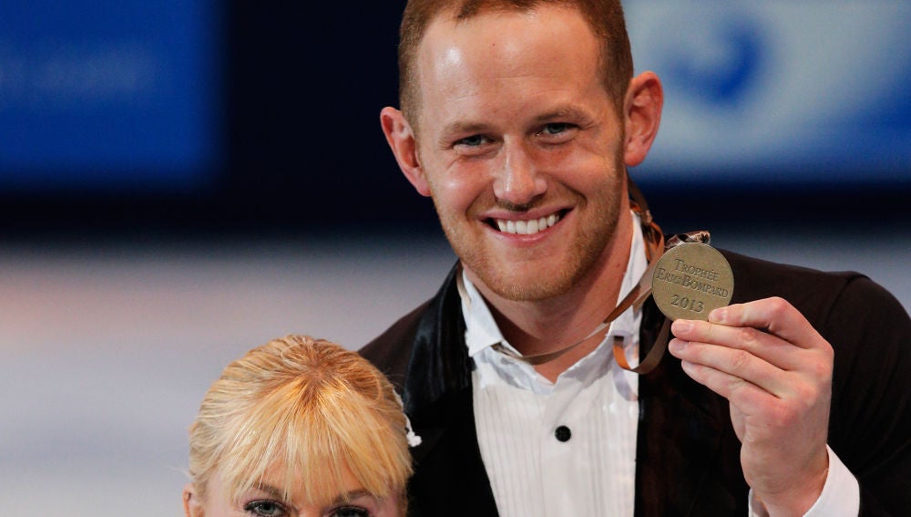 John Coughlin (derecha de la imagen) sonríe con una medalla