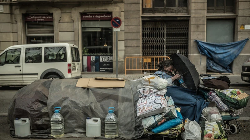 Una mujer con sus pertenencias en un banco de Madrid