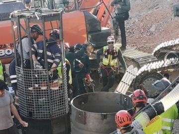 Miembros de la brigada de salvamento minero en la jaula antes de bajar por el túnel vertical