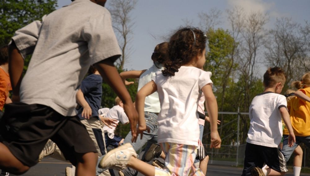 Imagen de archivo de niños corriendo en un colegio.