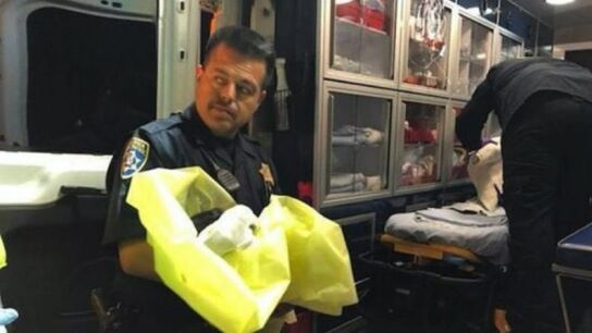 Un agente junto al beb&eacute; reci&eacute;n rescatado
