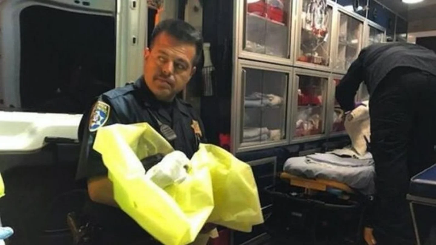Un agente junto al bebé recién rescatado Un agente junto al bebé recién rescatado