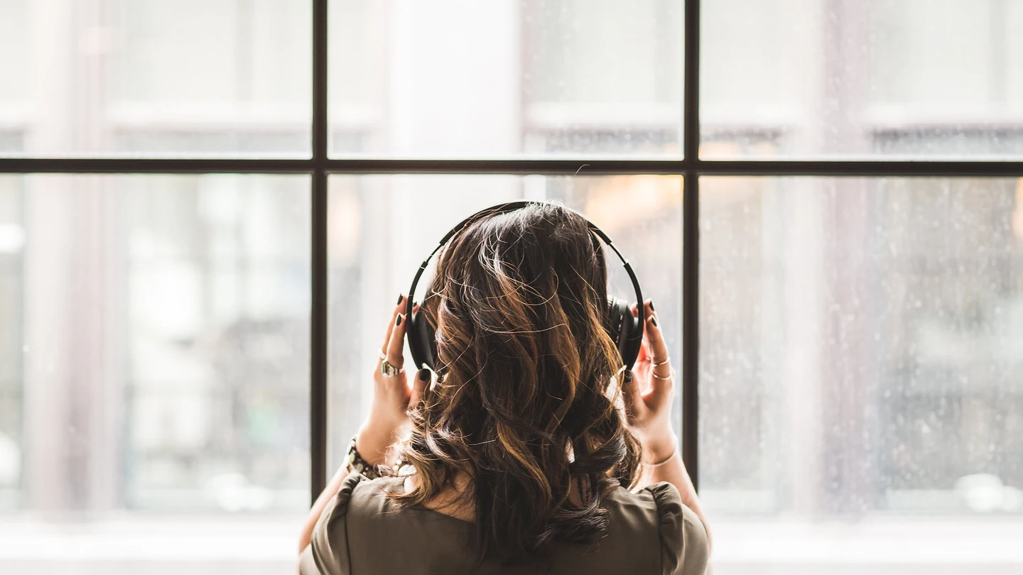 Una joven escucha música con auriculares Una joven escucha música con auriculares