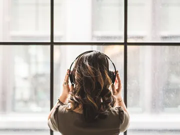 Una joven escucha música con auriculares Una joven escucha música con auriculares