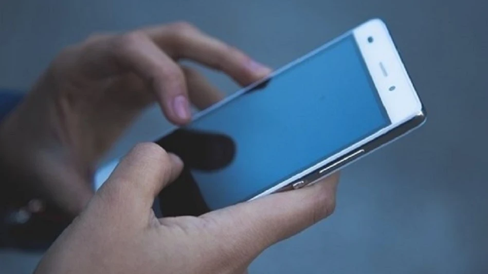 Imagen de archivo de una persona con un teléfono móvil en la mano