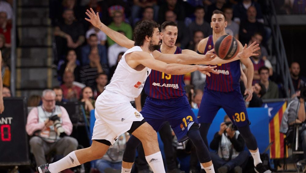 Llull intenta pasar el balón ante la defensa de los jugadores del Barcelona