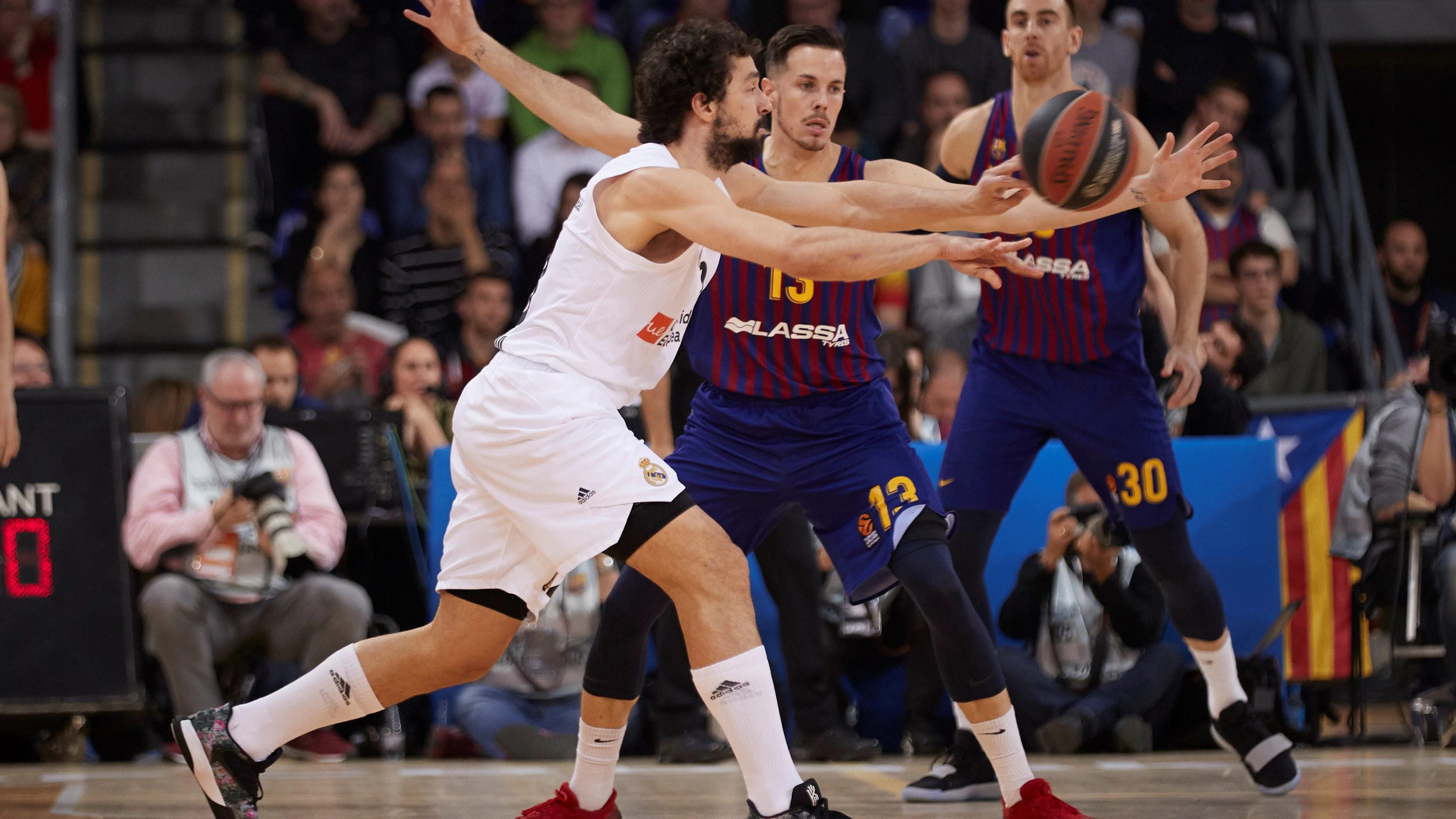 Llull intenta pasar el balón ante la defensa de los jugadores del Barcelona