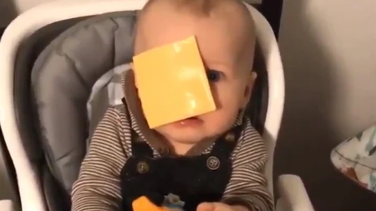 Un bebé con una loncha de queso en la cara. Un bebé con una loncha de queso en la cara.