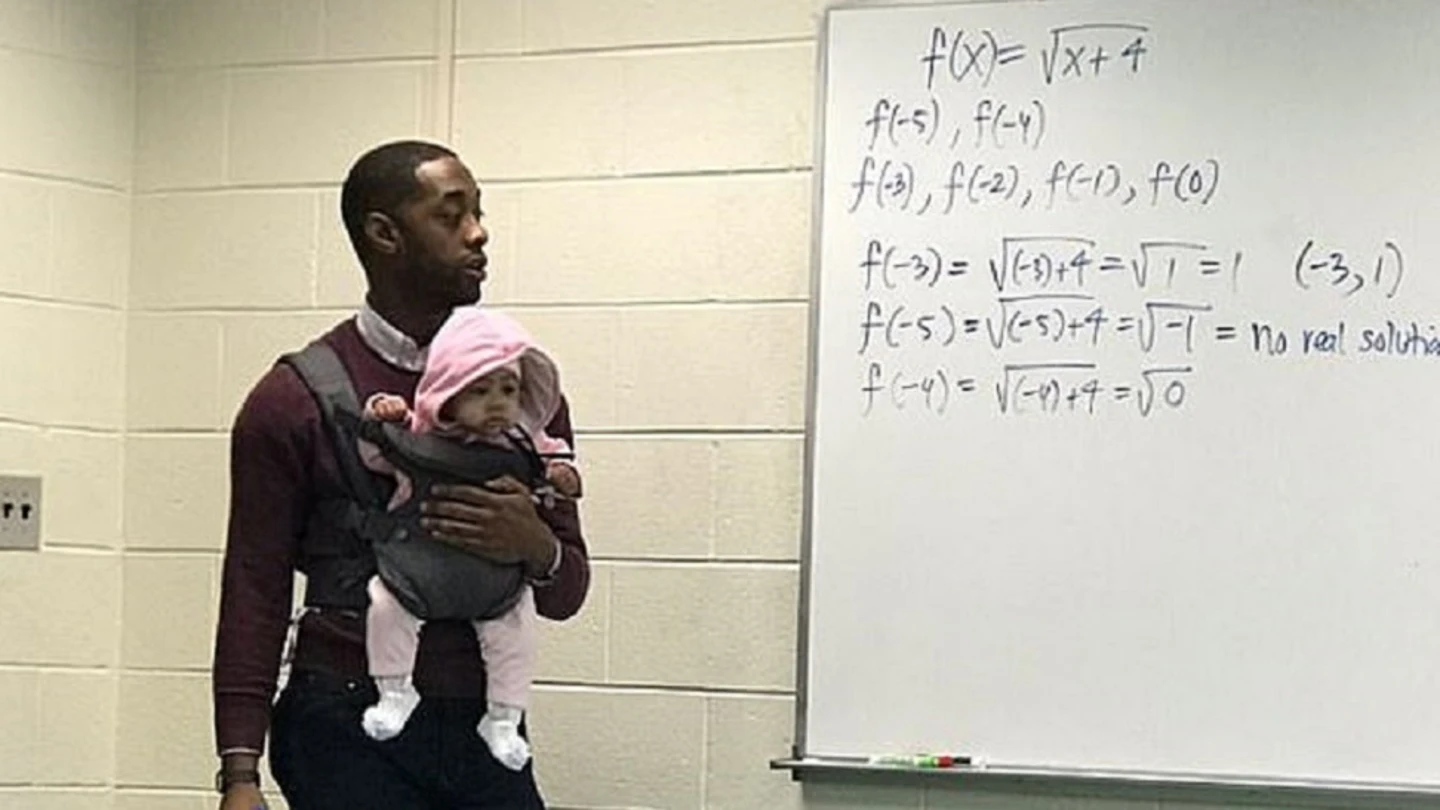 Imagen de un profesor con una bebé en brazos mientras daba clase Imagen de un profesor con una bebé en brazos mientras daba clase