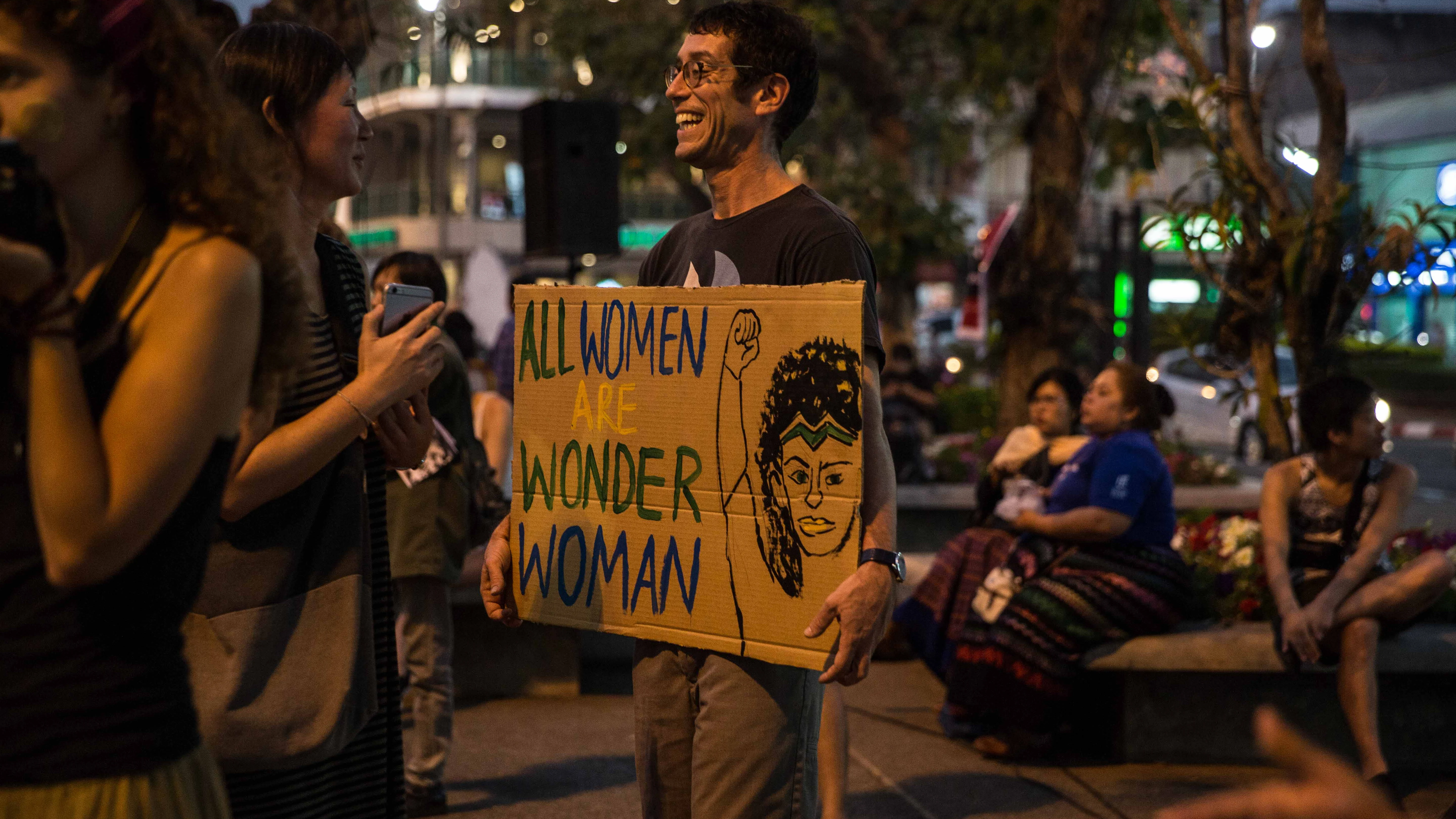 Un hombre sostiene una pancarta con el lema "Todas las mujeres son Wonder Woman" durante una manifestación por el Día Internacional de la Mujer en en Chiang Mai, Tailandia.