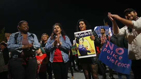 Hombres y mujeres en una manifestación del 8M en California, EEUU. Un hombre aplaude mientras tres mujeres caminan en una marcha de protesta por el 8M en Oakland, California.