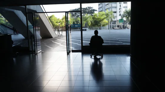 Un hombre mira por la ventana en una oficina sin luz en Caracas, Venezuela. Un hombre mira por la ventana en una oficina sin luz en Caracas, Venezuela.