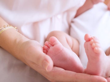 Una madre sosteniendo los pies de su bebé Una madre sosteniendo los pies de su bebé