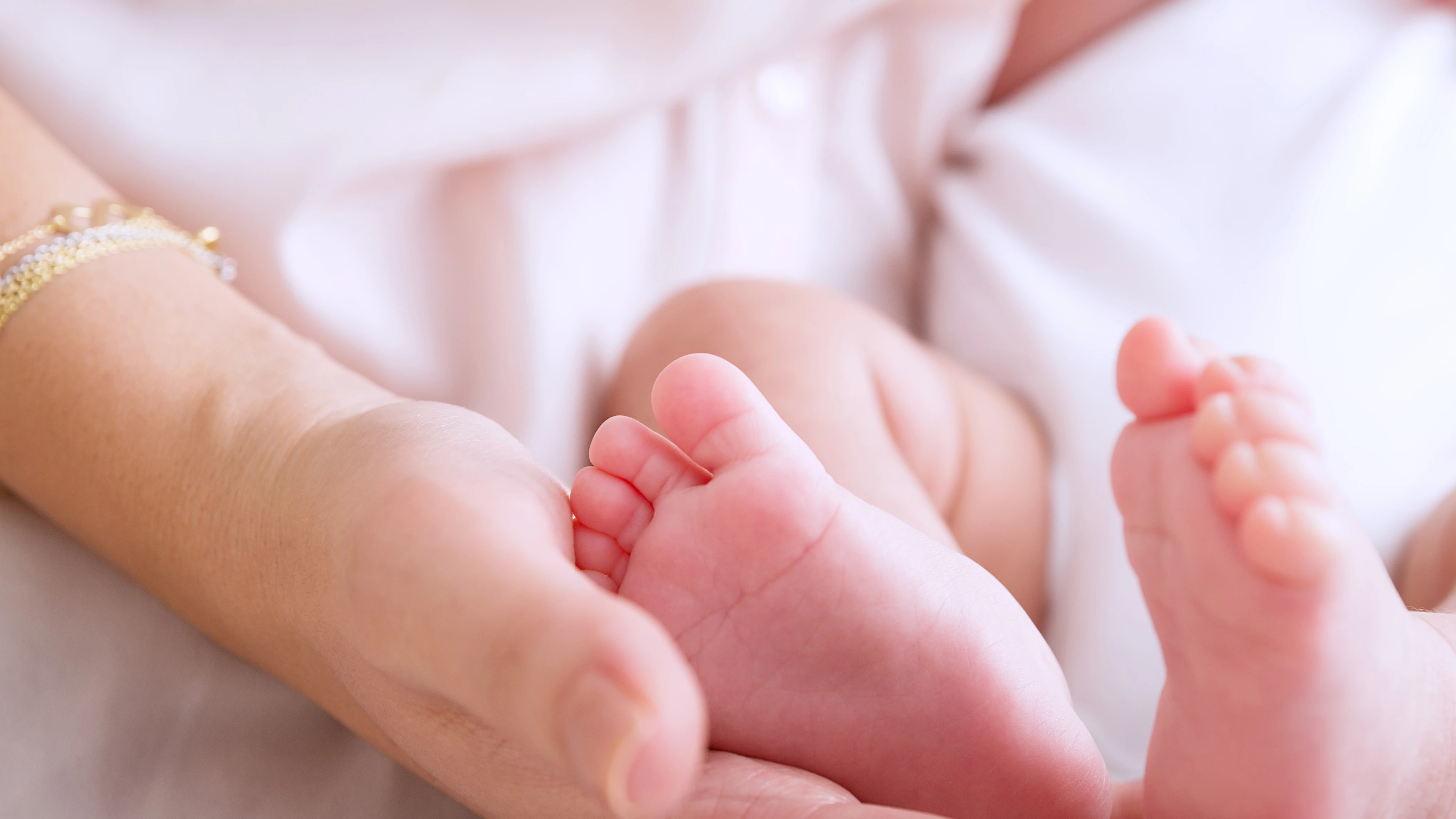 Una madre sosteniendo los pies de su bebé