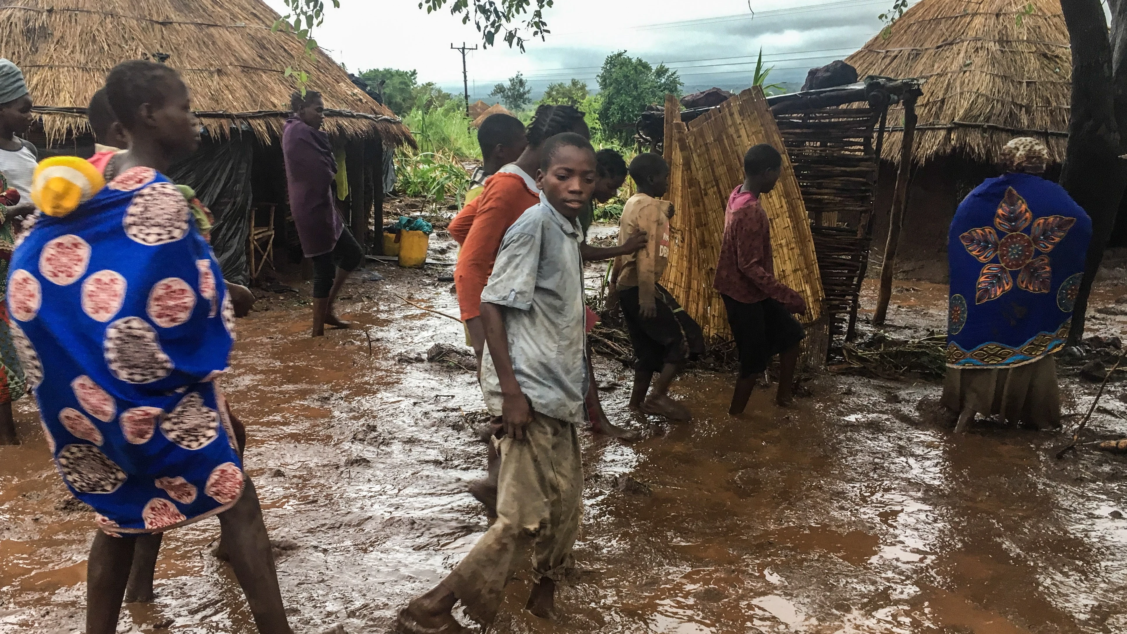 Habitantes de Chiluvi, una aldea del centro de Mozambique, caminan por una calle cubierta de lodo