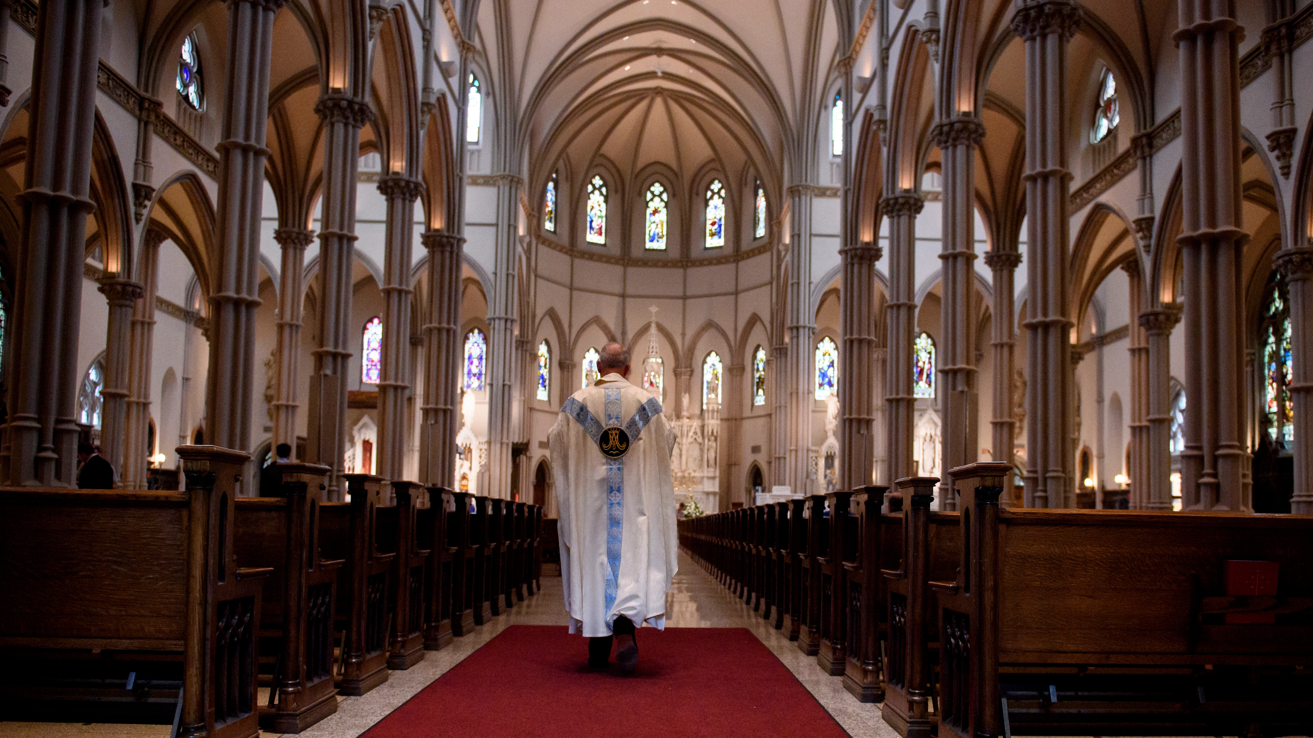 Un sacerdote camina por el pasillo de la Catedral de St Paul en Pittsburgh, Pensilvania