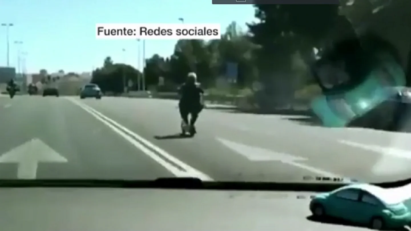 Una mujer conduce un patinete por la autovía de Valencia Una mujer conduce un patinete por la autovía de Valencia