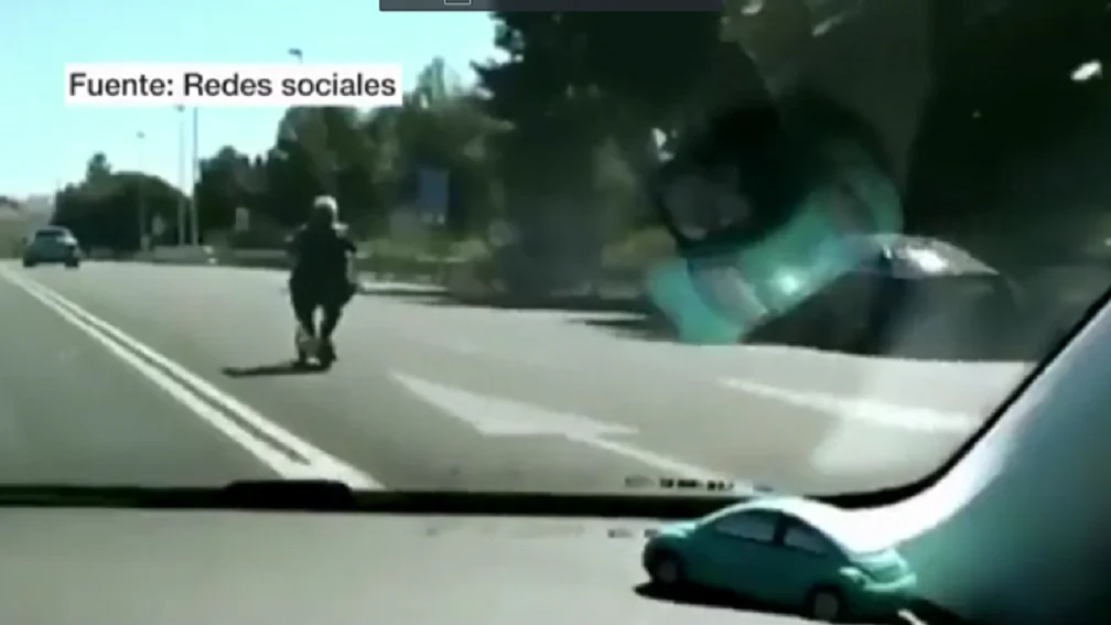 Una mujer conduce un patinete por la autovía de Valencia