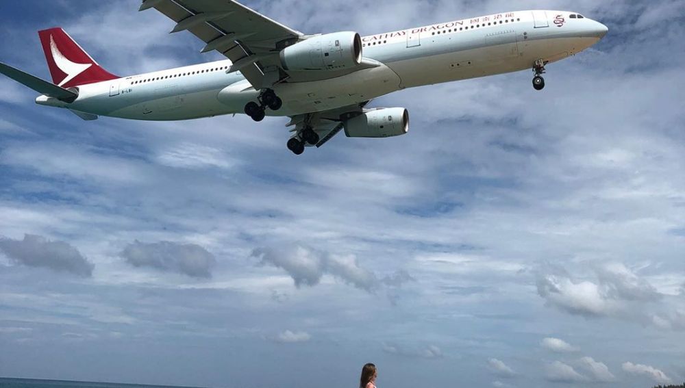 Imagen de una mujer junto a un avión en la playa a la que se ha prohibido el acceso