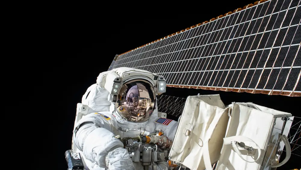 Scott Kelly trabajando en el mantenimiento de la ISS con los paneles solares al fondo