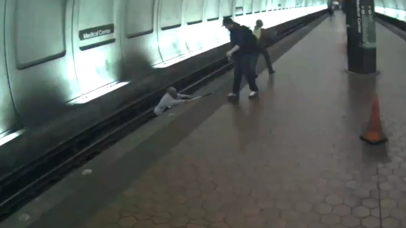 Un hombre intenta salir de las vías del metro en Maryland, EEUU.