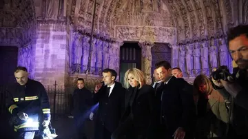 El presidente de Francia, Emmanuel Macron (c), y su esposa Brigitte Macron (c-d) visitan a los bomberos que intentan apagar el incendio en la catedral de Notre Dame
