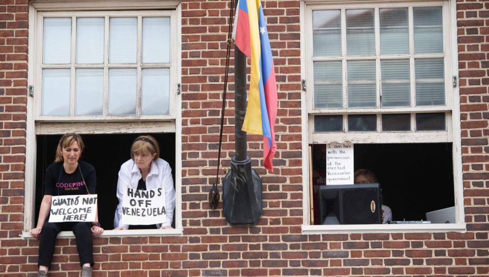 Acivistas con carteles contra Juan Guaidó en la embajada de Venezuela en Washington