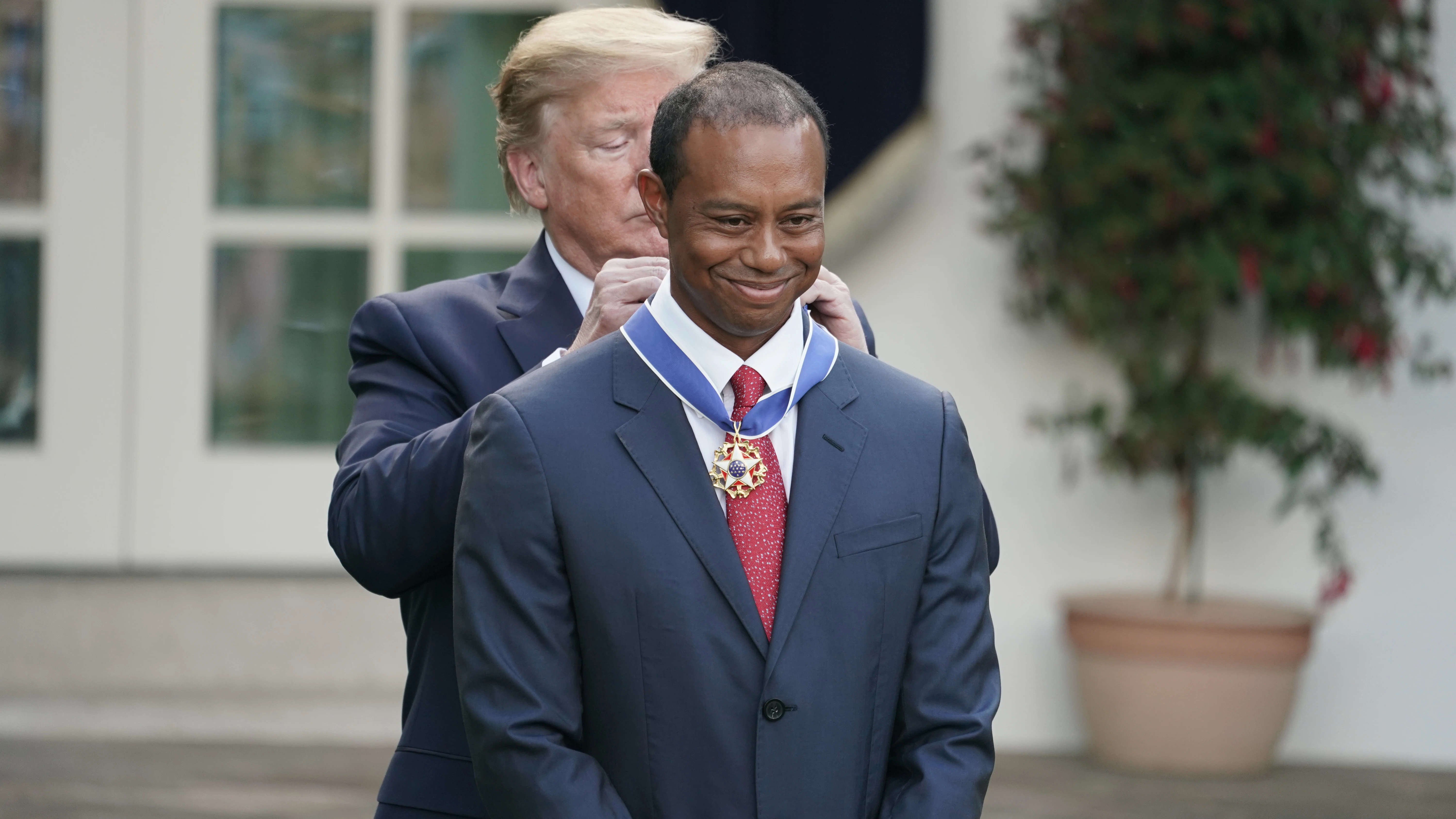 Donald Trump poniéndole la medalla a Tiger