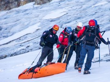 Miembros del equipo de rescate transportan un cuerpo hallado en el cerro Rincón de los Andes Miembros del equipo de rescate transportan un cuerpo hallado en el cerro Rincón de los Andes