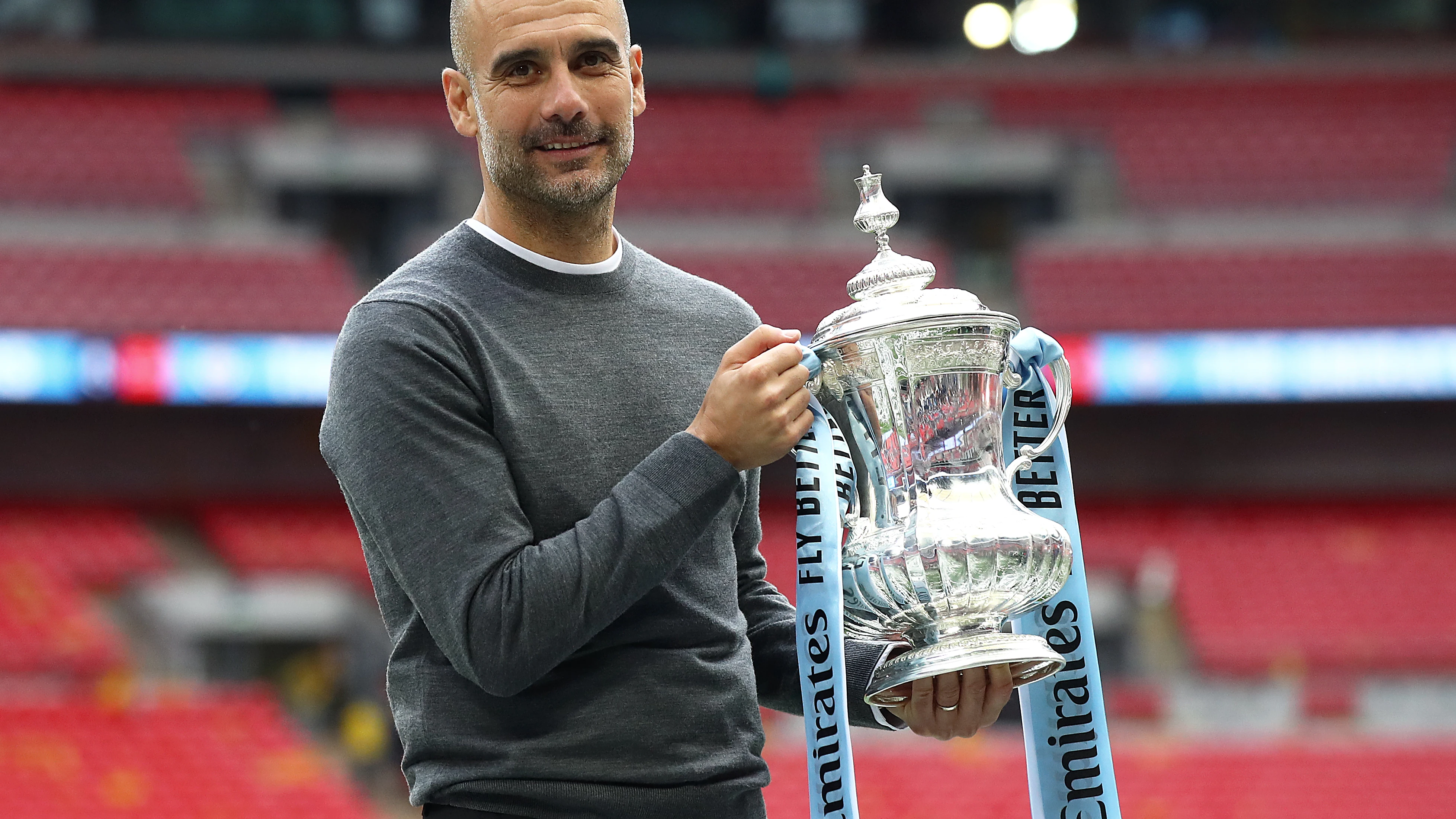 Guardiola posa sonriente con el trofeo de la FA Cup