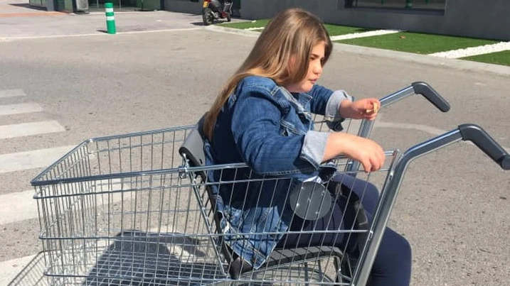 Imagen de la niña con movilidad reducida en un carro adaptado del Mercadona