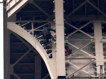 Un hombre escala la Torre Eiffel mientras varios bomberos tratan de detenerlo Un hombre escala la Torre Eiffel mientras varios bomberos tratan de detenerlo