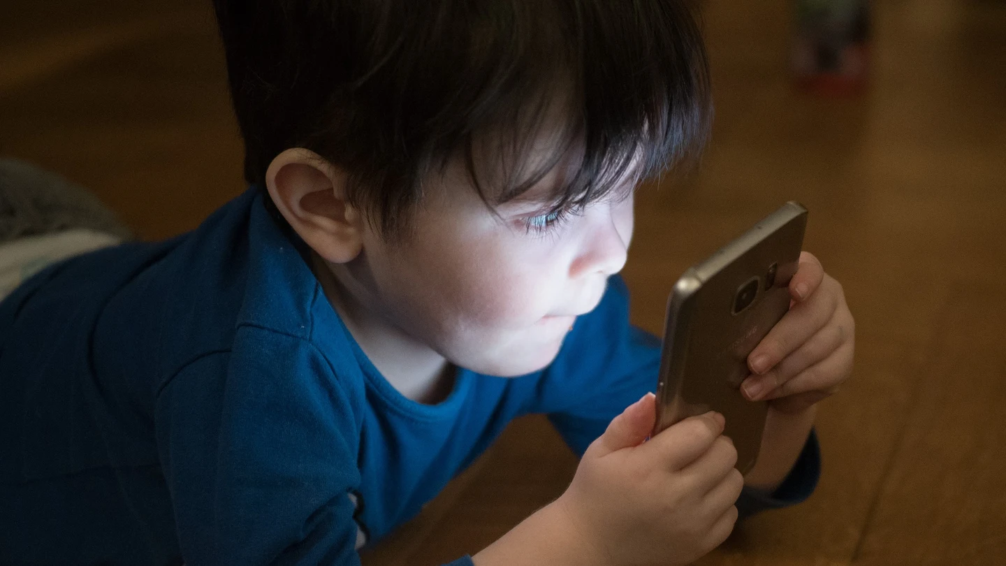 Imagen de archivo de un niño usando un teléfono móvil Nova Life