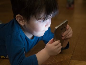 Niño usando un teléfono móvil Niño usando un teléfono móvil