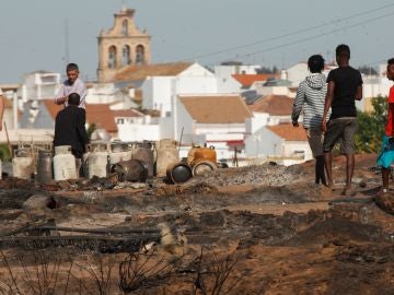 Varias personas caminan por lo que queda del asentamiento chabolista Varias personas caminan por lo que queda del asentamiento chabolista