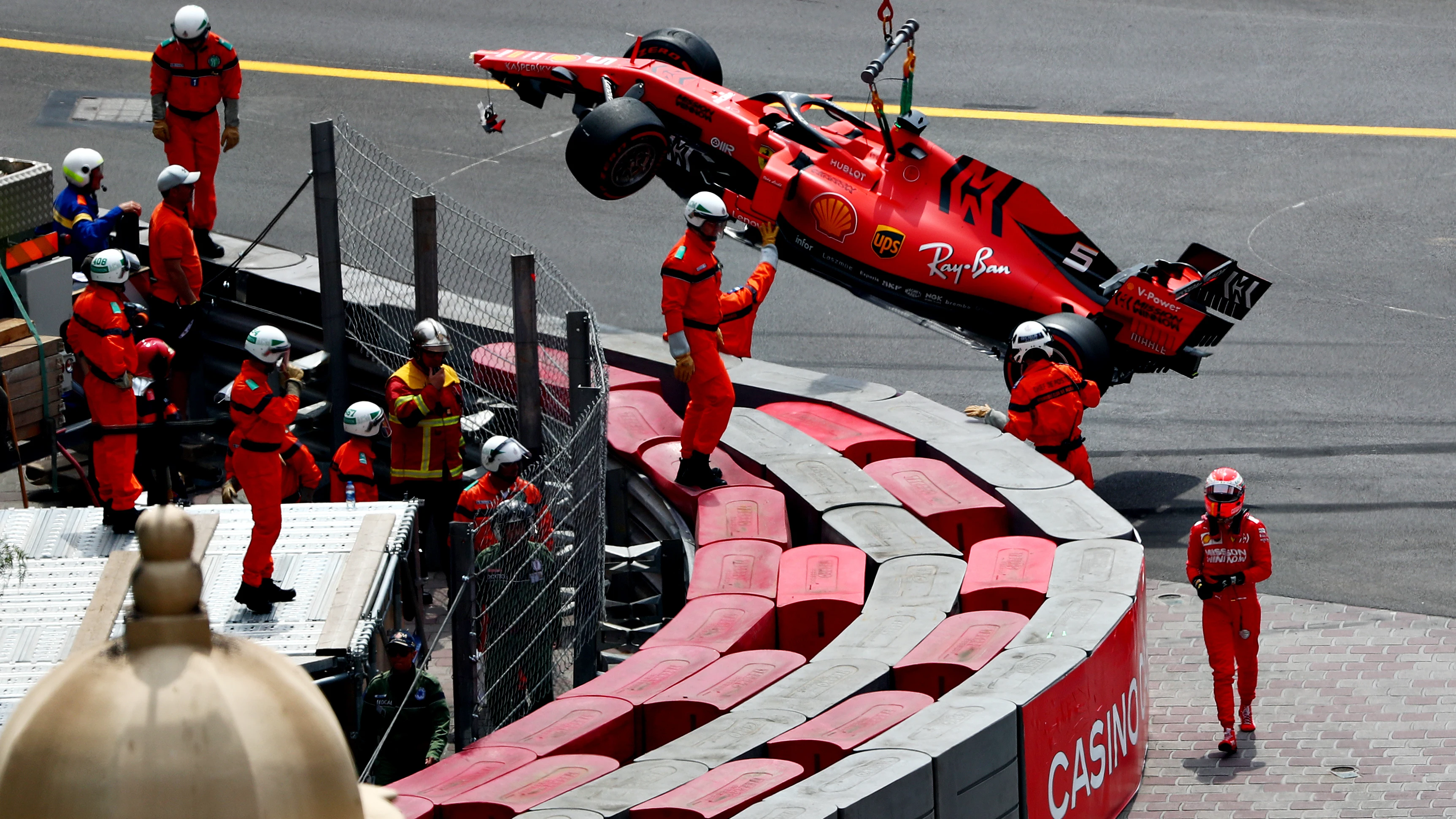 Los operarios retiran el Ferrari de Vettel de la pista tras el accidente del alemán