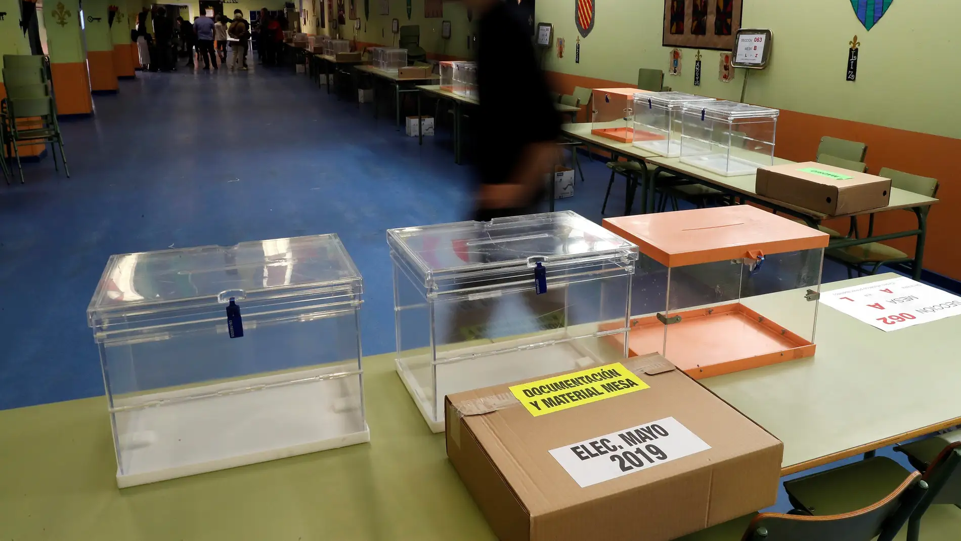 Trabajadores preparan las mesas electorales en un colegio público madrileño