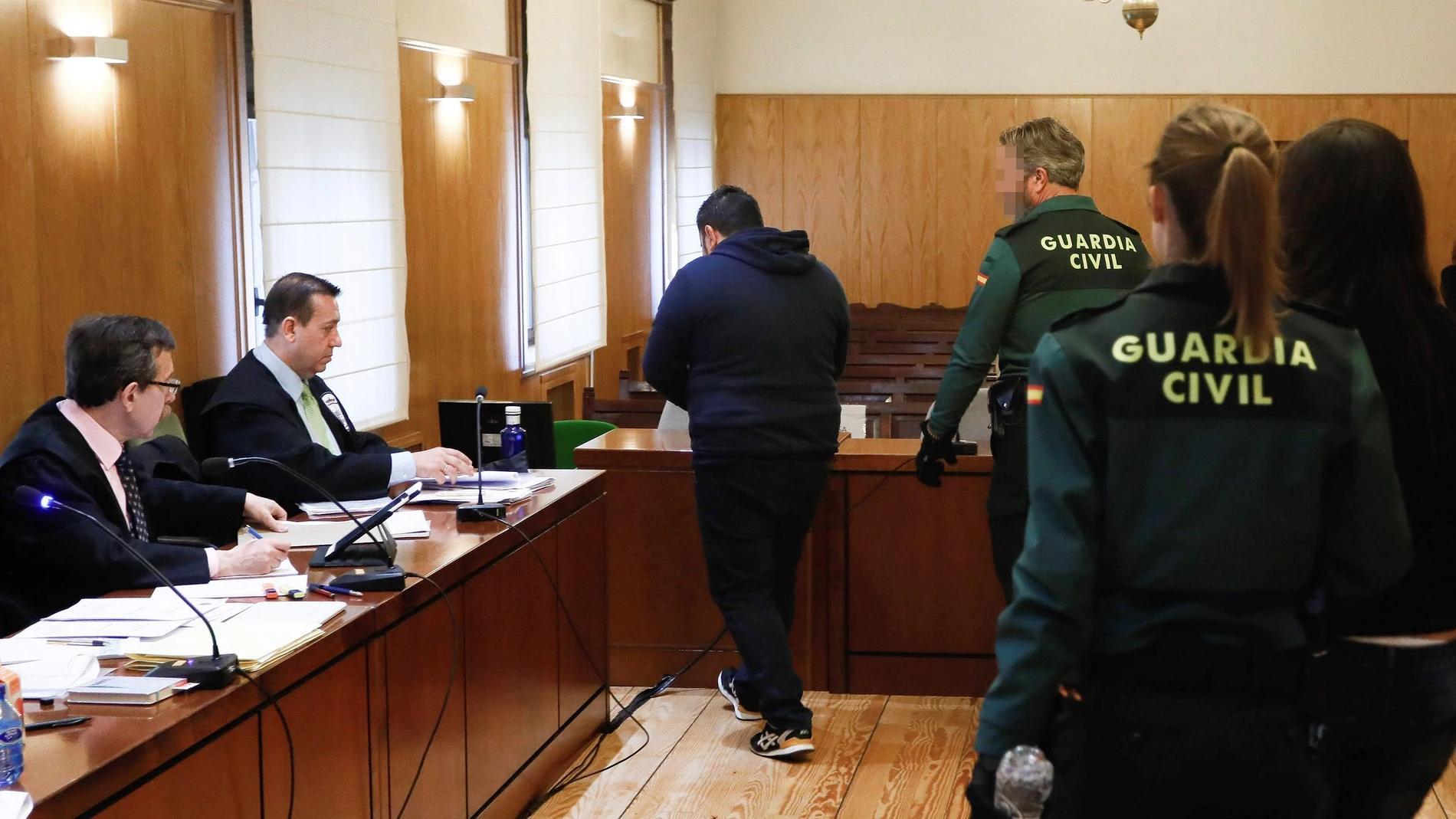 Los dos acusados entrando en la sala esposados por la Guardia Civil