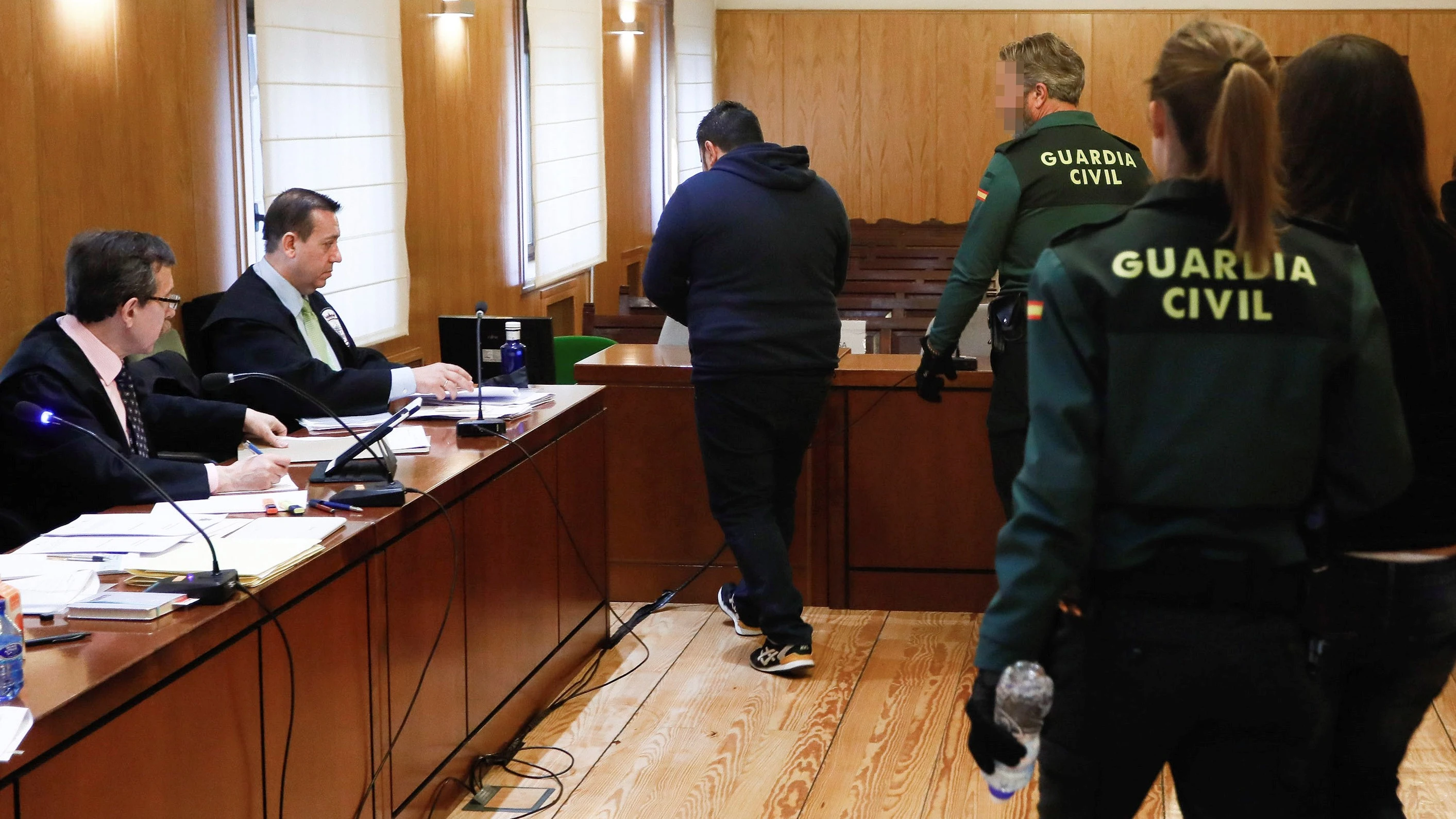 Los dos acusados entrando en la sala esposados por la Guardia Civil