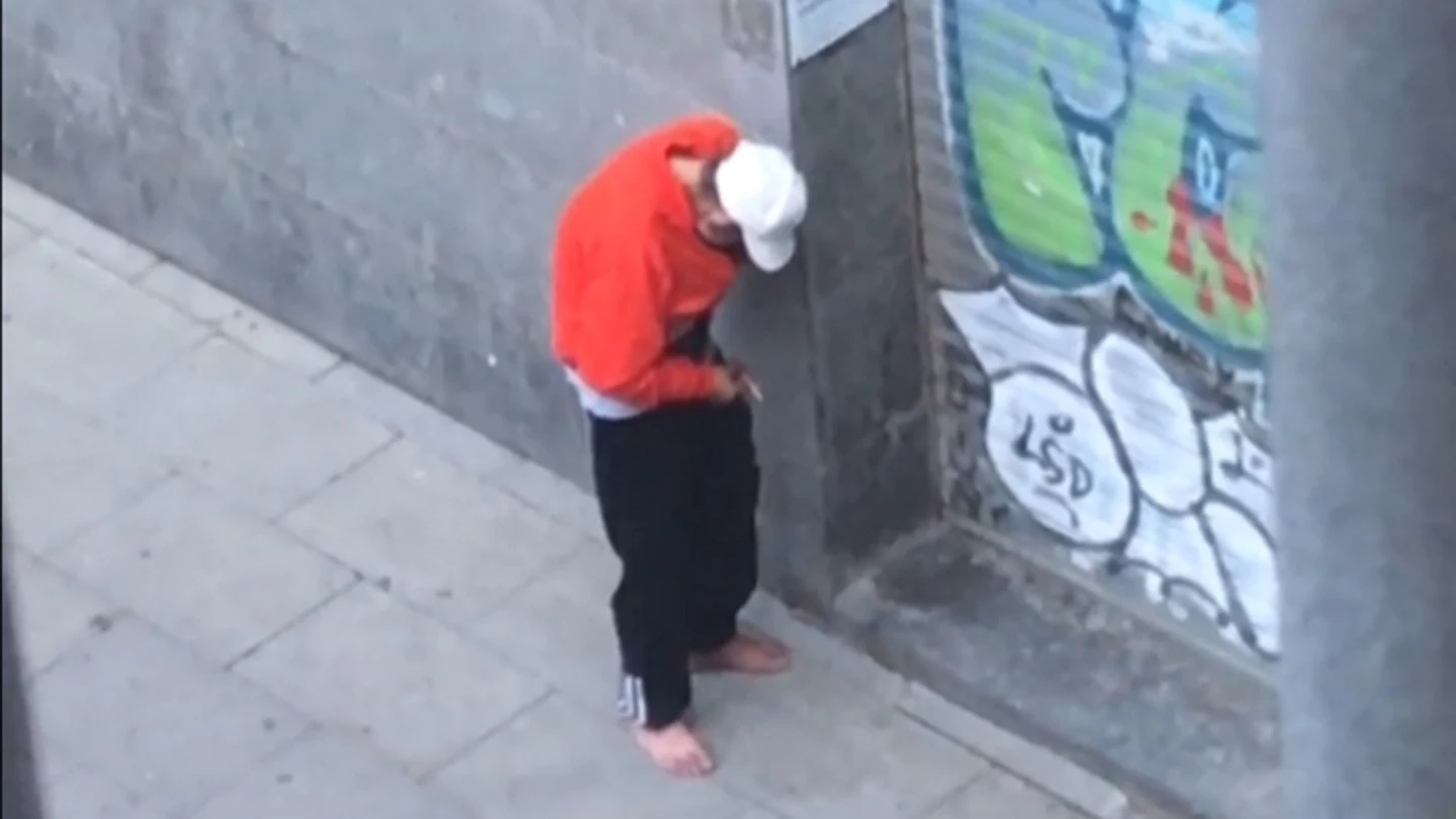 Un toxicómano consumiendo droga junto a un parque infantil Un toxicómano consumiendo droga junto a un parque infantil