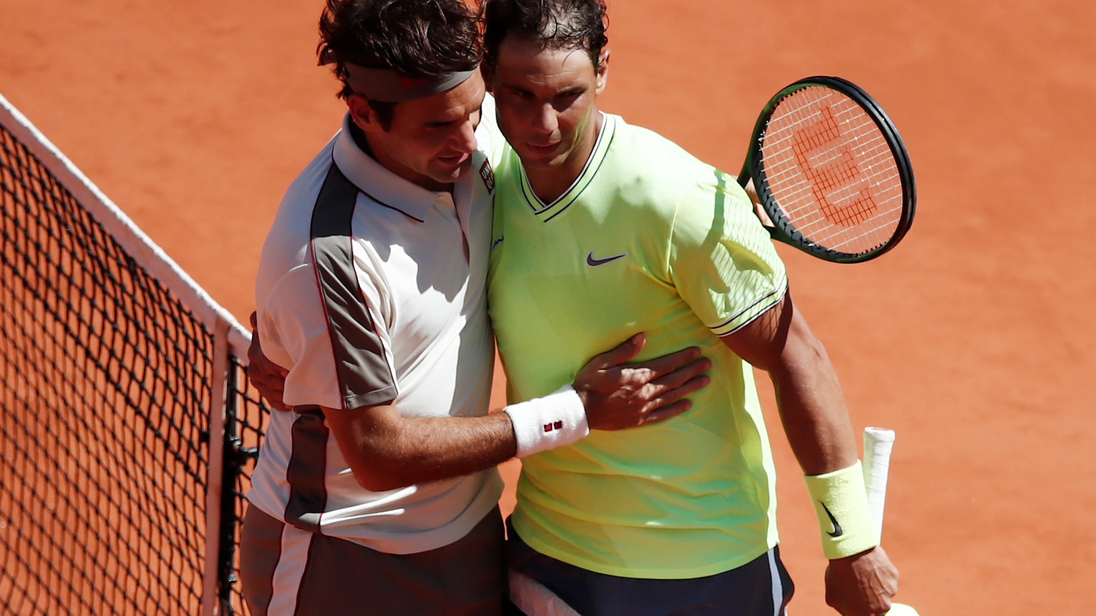 Roger Federer y Rafa Nadal se abrazan después de su partido en Roland Garros