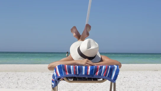 Una mujer toma el sol en una playa Una mujer toma el sol en una playa